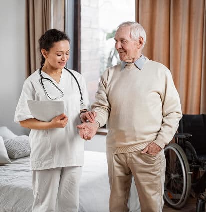 A support worker walking beside and assisting an older man